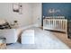 Bedroom with crib, glider, and ottoman, featuring a blue accent wall at 1018 Wilks Ave, Belle Isle, FL 32809