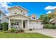 Tan two-story house with a two-car garage and manicured lawn at 1018 Wilks Ave, Belle Isle, FL 32809