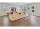 Living room showcasing hardwood floors and a beige sofa, with backyard access at 1018 Wilks Ave, Belle Isle, FL 32809