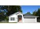 Newly built home with gray exterior, orange door, and two-car garage at 1101 E Pierce Ave, Orlando, FL 32809