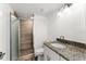 Updated bathroom with granite countertop, white cabinets, and a walk-in shower at 3807 S Atlantic Ave # 2020, Daytona Beach, FL 32118