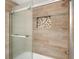 Shower with glass sliding door and decorative tile detail at 3807 S Atlantic Ave # 2020, Daytona Beach, FL 32118
