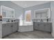 Spacious bathroom with double vanity, soaking tub, and gray cabinets at 3814 Golden Feather Way, Kissimmee, FL 34746