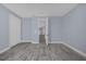 Well-lit bedroom with wood-look floors and access to another room at 3814 Golden Feather Way, Kissimmee, FL 34746