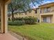 Landscaped backyard with grassy area and partial view of townhouses at 408 Miramar Avenue, Davenport, FL 33897