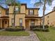 Front view of two-story townhome with landscaped yard at 408 Miramar Avenue, Davenport, FL 33897