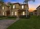 Two-story townhome with brick paver driveway and landscaped lawn at 408 Miramar Avenue, Davenport, FL 33897