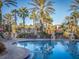 Tranquil pool with palm trees, lounge chairs, and reflecting sunlight at 408 Miramar Avenue, Davenport, FL 33897
