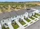 Aerial view of townhouses with gray roofs, green landscaping, and solar panels at 397 Madison Dr, Davenport, FL 33837