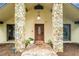 Front entrance with stone columns and a wood door at 4333 Woodlynne Ln, Orlando, FL 32812