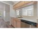 Kitchen with double sink, stainless steel dishwasher and view to living area at 13303 Pinyon Dr, Clermont, FL 34711