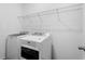 Bright laundry room with washer, dryer, and overhead shelving at 15211 Willow Arbor Cir, Orlando, FL 32824