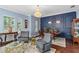 Elegant dining room features a dark-blue accent wall, hardwood floors, and a chandelier at 1940 Lobelia Dr, Lake Mary, FL 32746