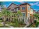 Tan three-story townhome with Spanish-style architecture and lush landscaping at 1940 Lobelia Dr, Lake Mary, FL 32746