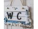 Nautical-themed bathroom sign with seashells and lighthouse at 2194 Cooper Bell Pl, Kissimmee, FL 34747