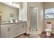 Bathroom with granite double vanity, large mirror, and walk-in shower at 3214 Gold Ln, Kissimmee, FL 34747