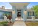 Front entrance with a covered porch, light fixtures, and a tiled walkway at 5016 Dorman Rd, Lakeland, FL 33813