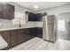 Modern kitchen with dark wood cabinets, stainless steel appliances, and quartz countertops at 143 N Woodward Ave, Deland, FL 32720