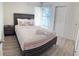 Cozy bedroom with a full-size bed, simple decor, and light wood floors at 2749 N Poinciana Blvd # 16, Kissimmee, FL 34746