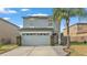 Two-story house with gray siding, a two-car garage, and a landscaped front yard at 3902 Rollingsford Cir, Lakeland, FL 33810