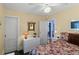 Floral-themed bedroom with ceiling fan, closet, and open door to adjacent room at 402 Oakwood Ave, New Smyrna Beach, FL 32169