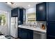 Compact kitchen with white countertops, blue cabinets, and back door at 402 Oakwood Ave, New Smyrna Beach, FL 32169