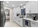 Modern kitchen with white cabinets, gray shiplap and quartz countertops at 47 Community Dr, Debary, FL 32713
