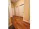 Bright hallway with wood-look floors and three doors leading to bedrooms at 6430 S Goldenrod Rd # 15B, Orlando, FL 32822