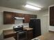 Galley-style kitchen with dark wood cabinets and stainless steel appliances at 2260 Cascades Blvd # 107, Kissimmee, FL 34741