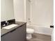 Clean bathroom with white tile, granite vanity, and tub at 3247 Sustainable Way, Kissimmee, FL 34747