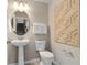 Modern bathroom with pedestal sink, toilet, and decorative wall art at 4515 Cypress Cay Way, Kissimmee, FL 34746