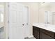 Bathroom with dark vanity, large mirror, and double doors at 8441 Chilton Dr, Orlando, FL 32836
