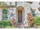 Elegant front entrance with arched stonework and a wood door at 8441 Chilton Dr, Orlando, FL 32836