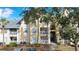 Front view of condo building, featuring a yellow exterior and lush landscaping at 1037 S Hiawassee Rd # 2815, Orlando, FL 32835