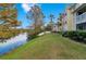 Scenic lakefront view with lush landscaping and mature trees at 1037 S Hiawassee Rd # 2815, Orlando, FL 32835