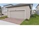 Attached garage with light beige door and brick pavers at 11968 Bracco St, Winter Garden, FL 34787