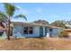 Light blue ranch home with palm trees and a spacious front yard at 1716 Sprucewood Ln, Orlando, FL 32818