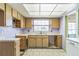 View of the kitchen with wood cabinets and a window at 1716 Sprucewood Ln, Orlando, FL 32818