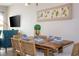Modern dining area with a wood table and teal accent chair at 172 Villa Domani Cir, Davenport, FL 33896