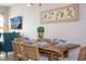 Modern dining area with a wood table and teal accent chair at 172 Villa Domani Cir, Davenport, FL 33896