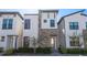 Modern three-story home with stone accents and a landscaped front yard at 172 Villa Domani Cir, Davenport, FL 33896