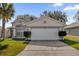 Front view of a single-story house with a two-car garage and landscaping at 2238 Wyndam Way, Kissimmee, FL 34743