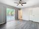 Bright bedroom with wood-look floors, sliding door to patio, and pool view at 3607 Datura Ct, Winter Park, FL 32792