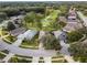 Aerial view of a residential community with houses, streets, and a golf course at 8019 Arcadian Ct, Mount Dora, FL 32757