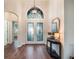 Bright and airy foyer with hardwood floors and a decorative mirror at 8019 Arcadian Ct, Mount Dora, FL 32757