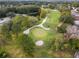 Aerial view of a golf course with a green and sand traps at 8019 Arcadian Ct, Mount Dora, FL 32757