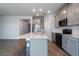 Modern kitchen with gray cabinets, quartz countertops, and stainless steel appliances at 1703 Chatsworth Cir, Saint Cloud, FL 34771