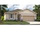 One-story home with light beige siding, stone accents, and a two-car garage at 1708 Columbus Path, St Cloud, FL 34771