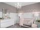 Charming Bedroom with white and grey color scheme, crib, and chandelier at 2037 Calm Soul Way, Kissimmee, FL 34744