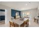 Dining room with light wood table and chairs, blue accent wall at 2570 Winsome Way, Davenport, FL 33896